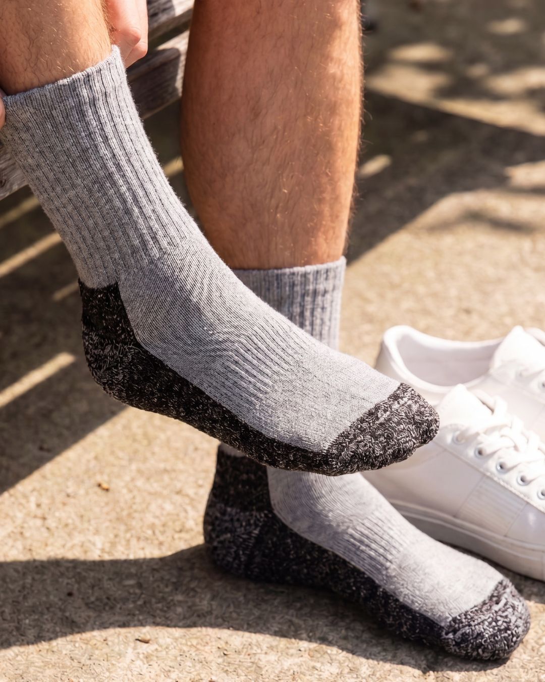 Model wearing gray PeakPaca Hiker Socks outdoors with the reinforced sole visible