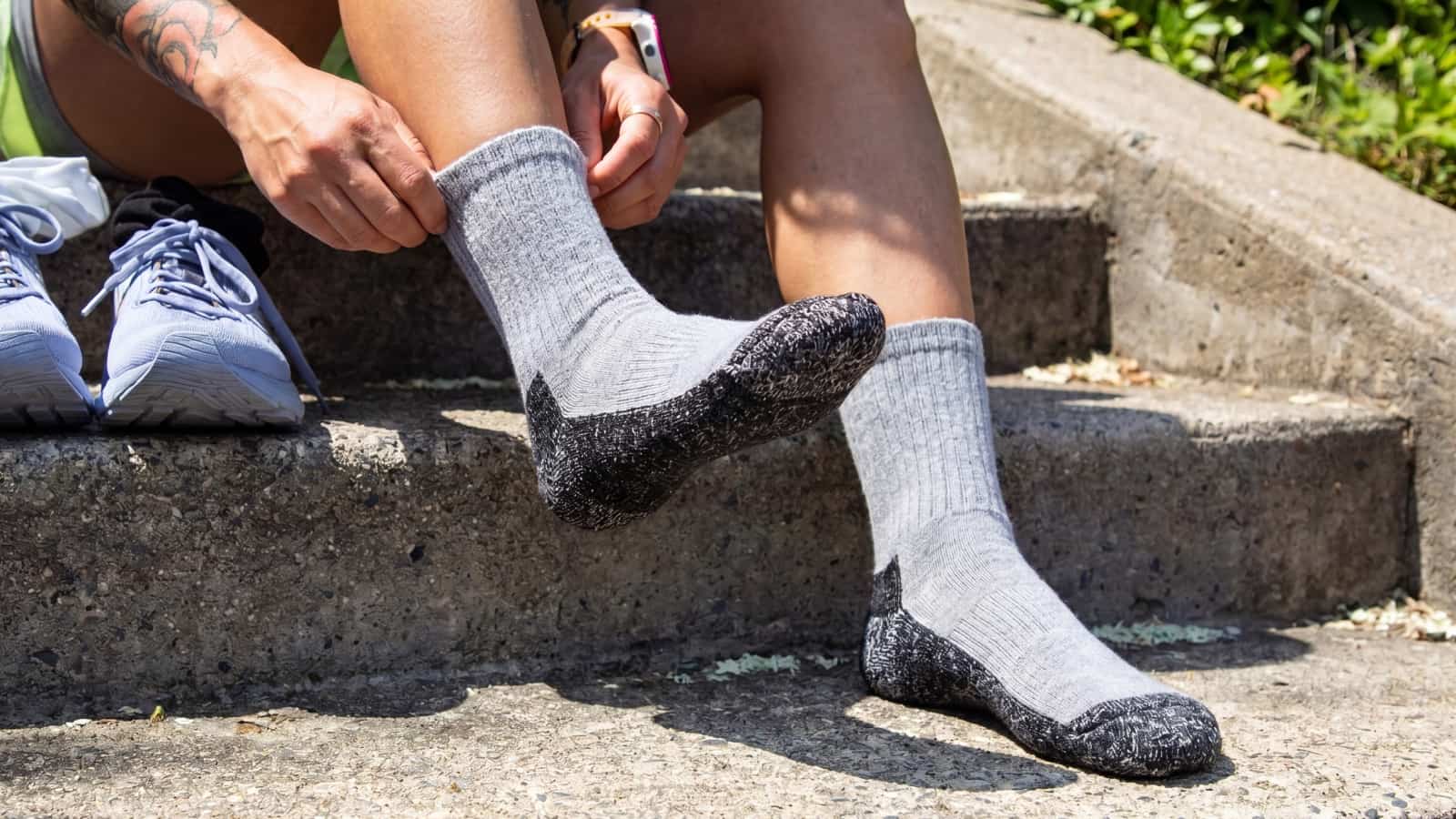 Model wearing gray PeakPaca Hiker Socks outdoors with the reinforced sole visible