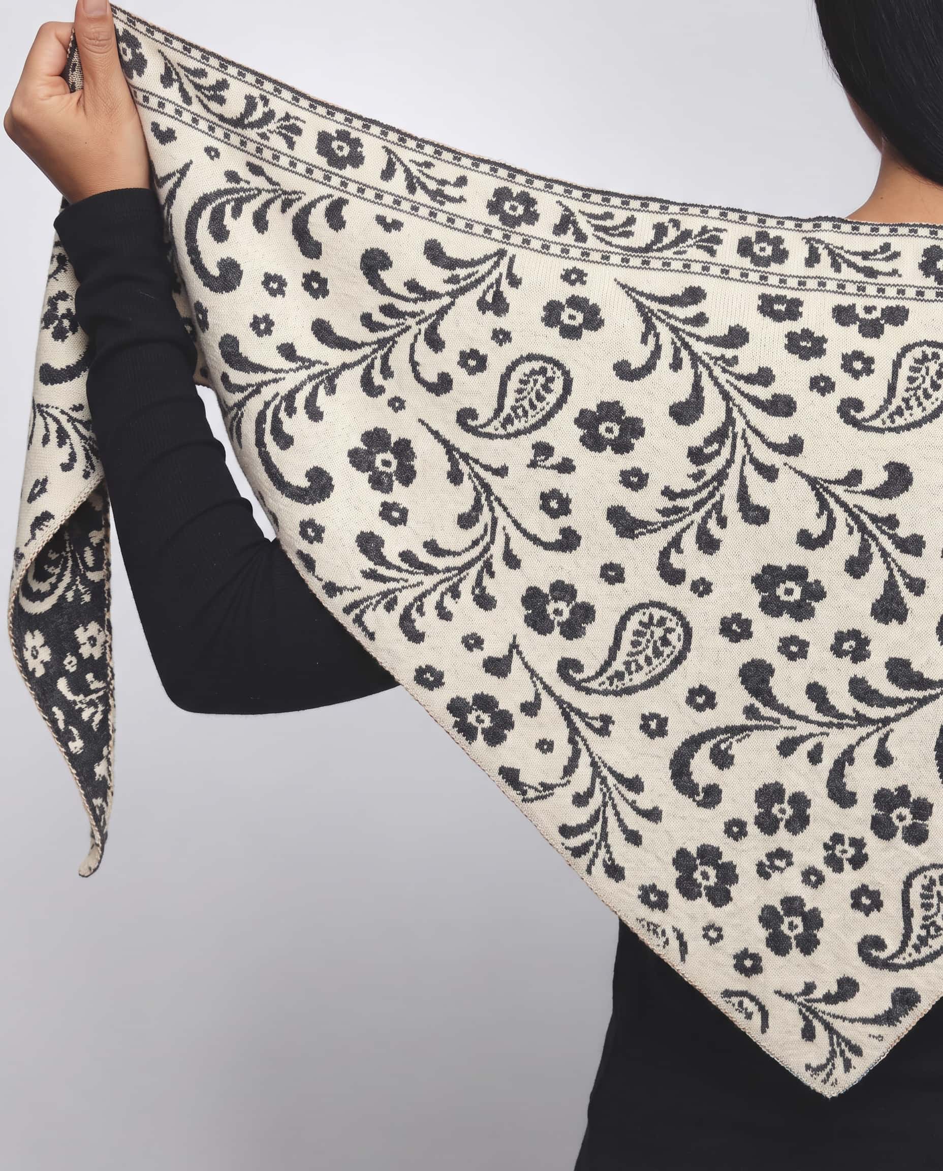 Grey and white reversible paisley triangle scarf paired with charcoal jacket
