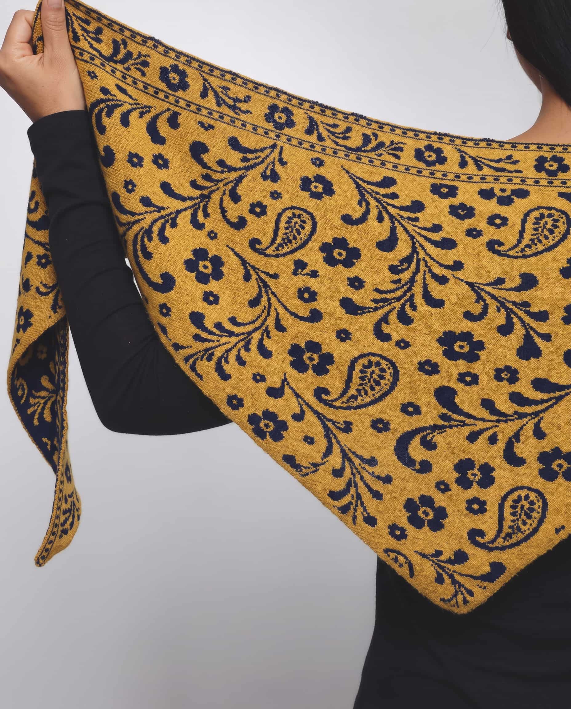 Navy and mustard gold triangle scarf with gold face showing against a dark tailored outfit